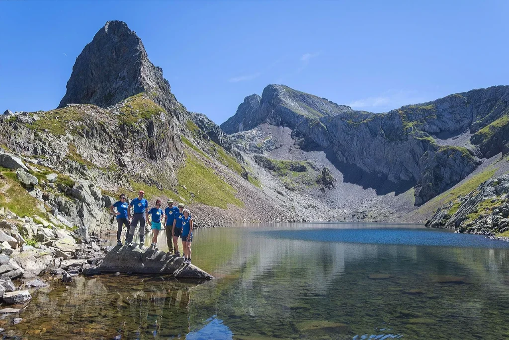 Grupo realizando 3000 ibones con guía de montaña junto a un ibón